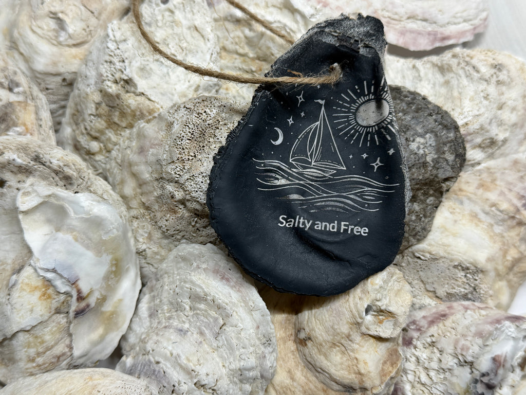 Black bag with 'Salty and Free' text and sailboat design on textured stone background