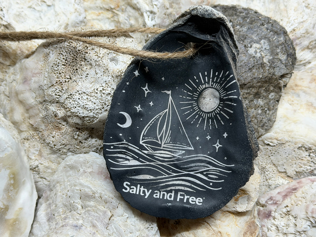 Black bag with sailboat design and 'Salty and Free' text on a stone background