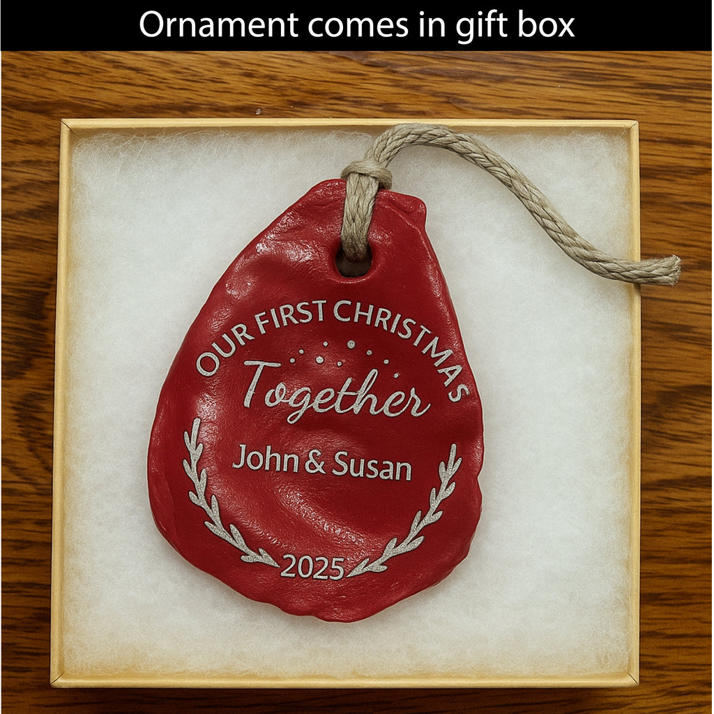 Red ornament with 'Our First Christmas Together' text in a gift box on a wooden surface