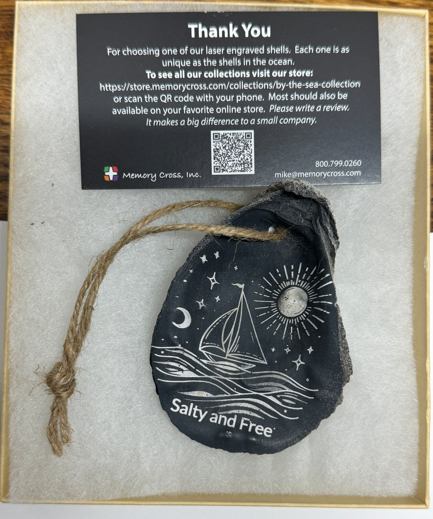 Decorative engraved shell with 'Salty and Free' text, tied with twine, on a branded card.